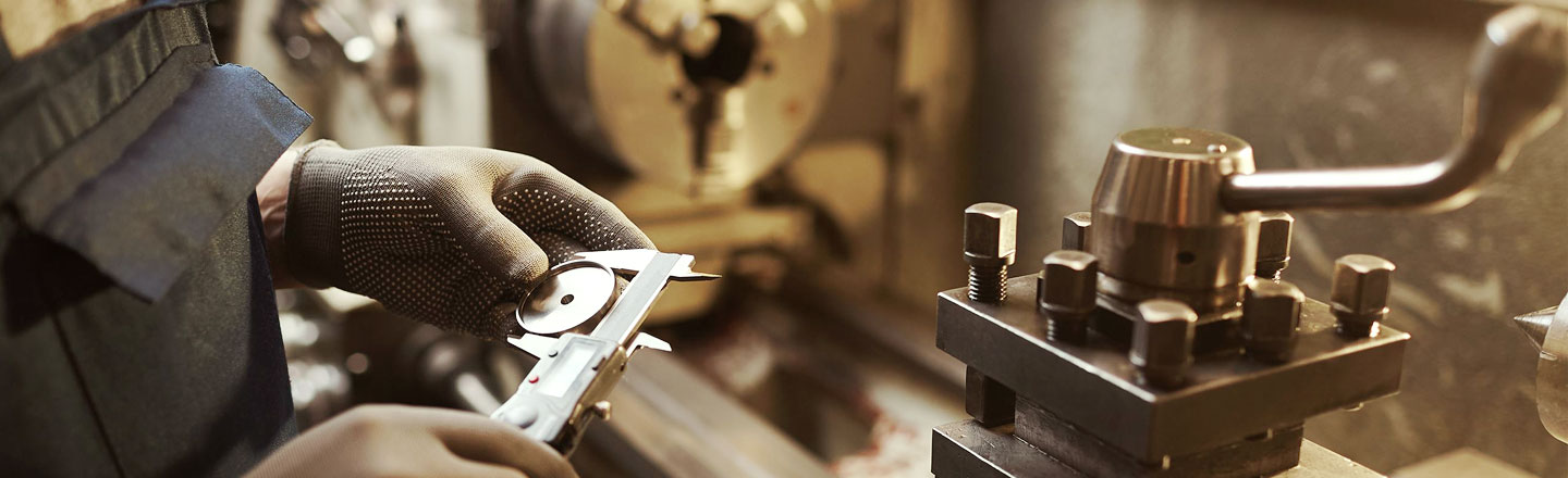 Worker completing precision work with metal product